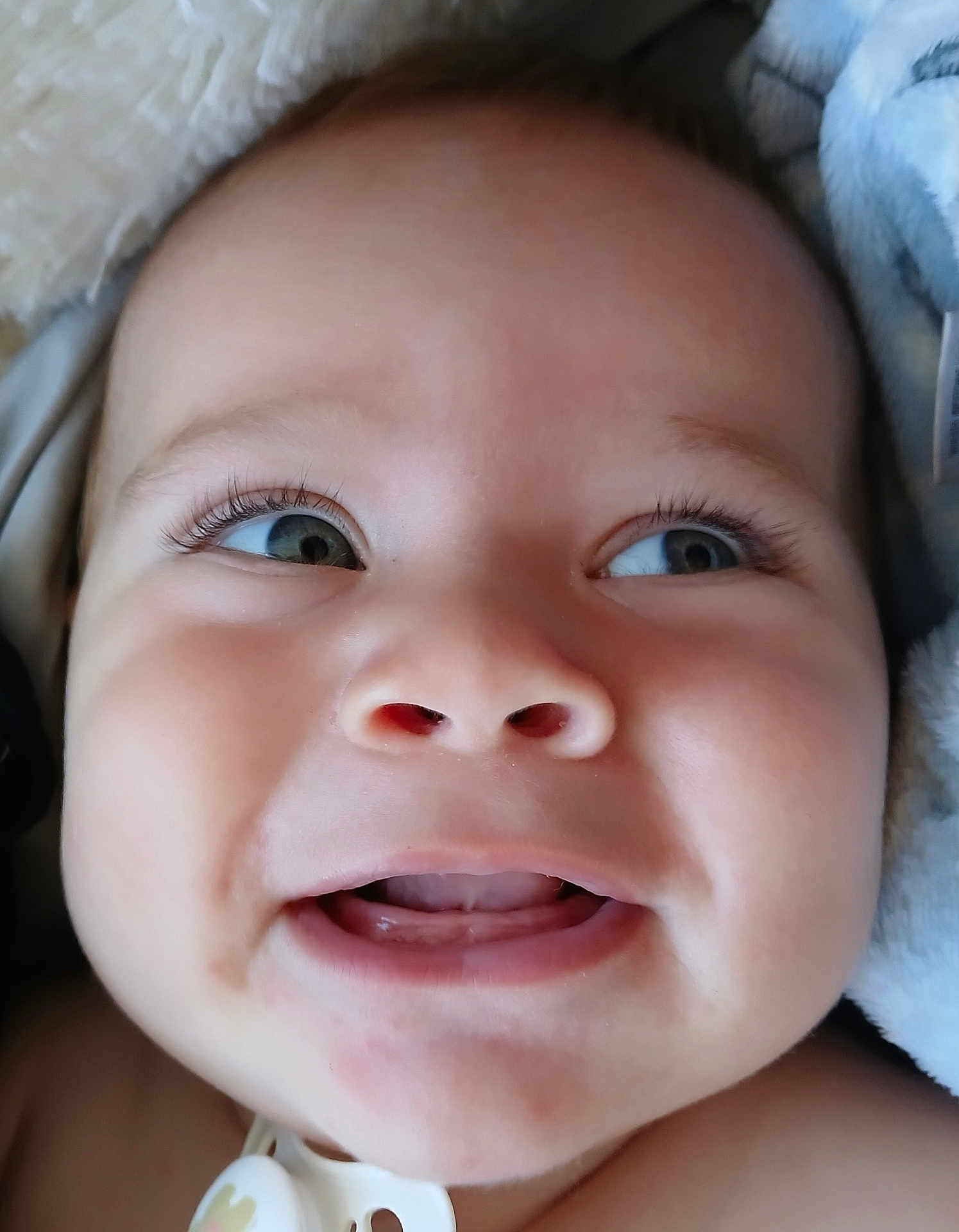 Kawikaonalaniekapu is registered to the contest to win money with this photo: baby, face, closeup, infant, cute, eyes, mouth, skin, expression, blanket, soft, adorable, child, pacifier, portrait, smile, cheeks, newborn, happy, person