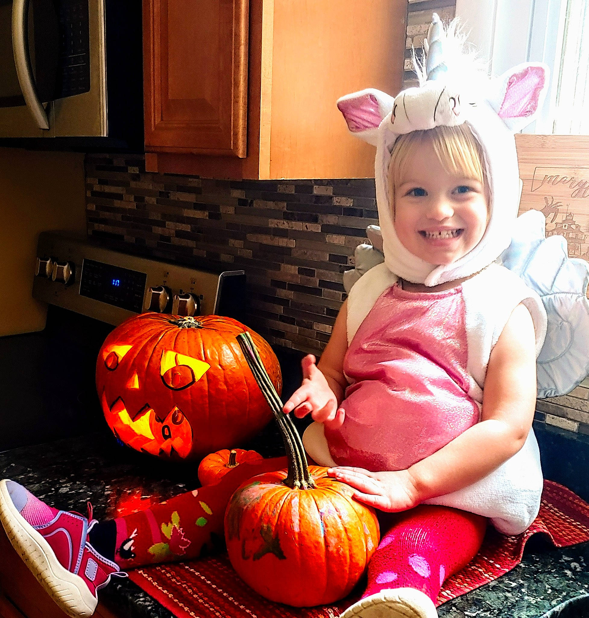 Ameline is registered to the contest to win money with this photo: baby_toddler_clothing, cabinetry, calabaza, cucurbita, eye, gourd, happy, hat, iris, joy, kitchen_appliance, natural_foods, orange, person, pumpkin, purple, smile, snapshot, squash, toddler