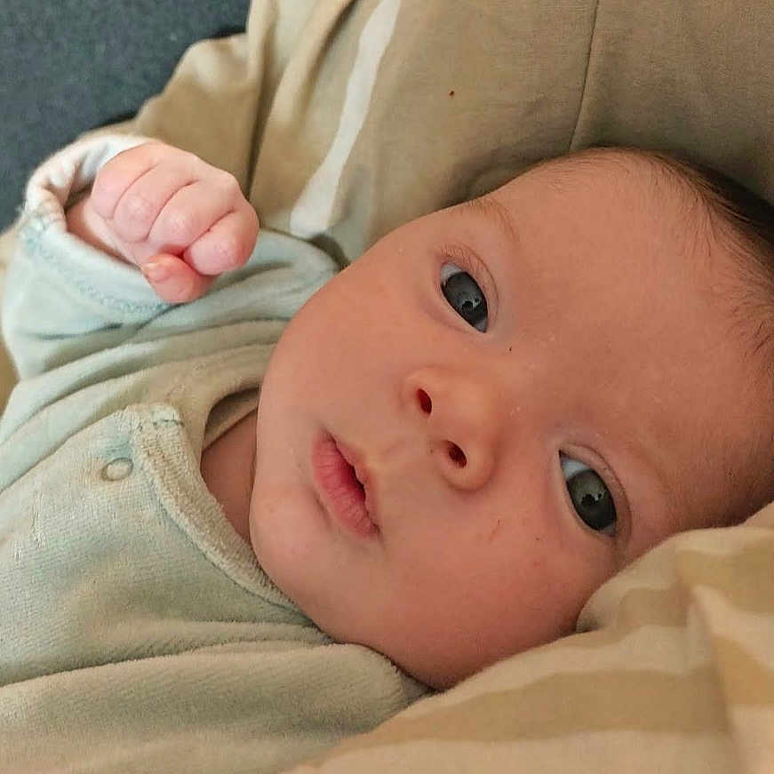 Emmy a rejoint le concours — aidez-le/la à gagner de superbes lots ! baby, newborn, infant, child, face, eyes, hand, fist, onesie, blanket, bedding, closeup, portrait, lying_down, skin, adorable, cozy, indoors, expression, awake