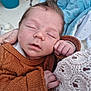 Néven participe au concours pour gagner de l'argent avec cette photo : baby, brown_sweater, calm, child, closed_eyes, cozy, crochet, cute, face, hair, hand, holding, infant, knitwear, mohawk, person, skin, sleeping, texture, white