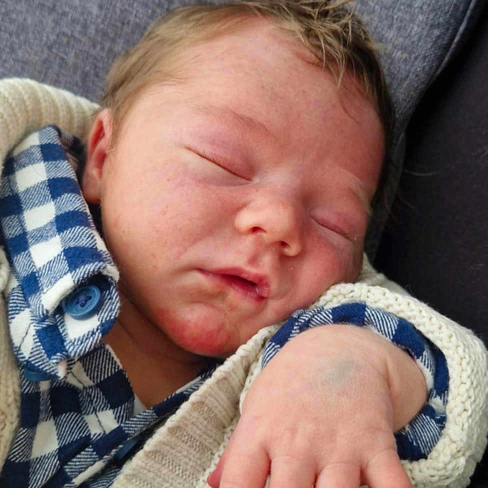 Néven a rejoint le concours — aidez-le/la à gagner de superbes lots ! baby, blue_checkered_shirt, casual_clothing, child, close_up, cozy, cushion, face, hand, indoors, infant, knitted_sweater, newborn, peaceful, portrait, relaxation, resting, skin, sleeping, soft