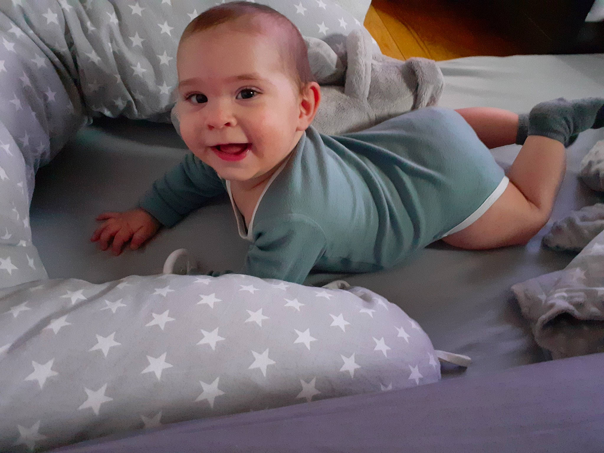 Valentin participe au concours pour gagner de l'argent avec cette photo : arm, baby, baby_toddler_clothing, child, comfort, crawling, eye, face, finger, grey, head, human_body, joy, linens, mouth, person, sitting, sleeve, smile, t_shirt