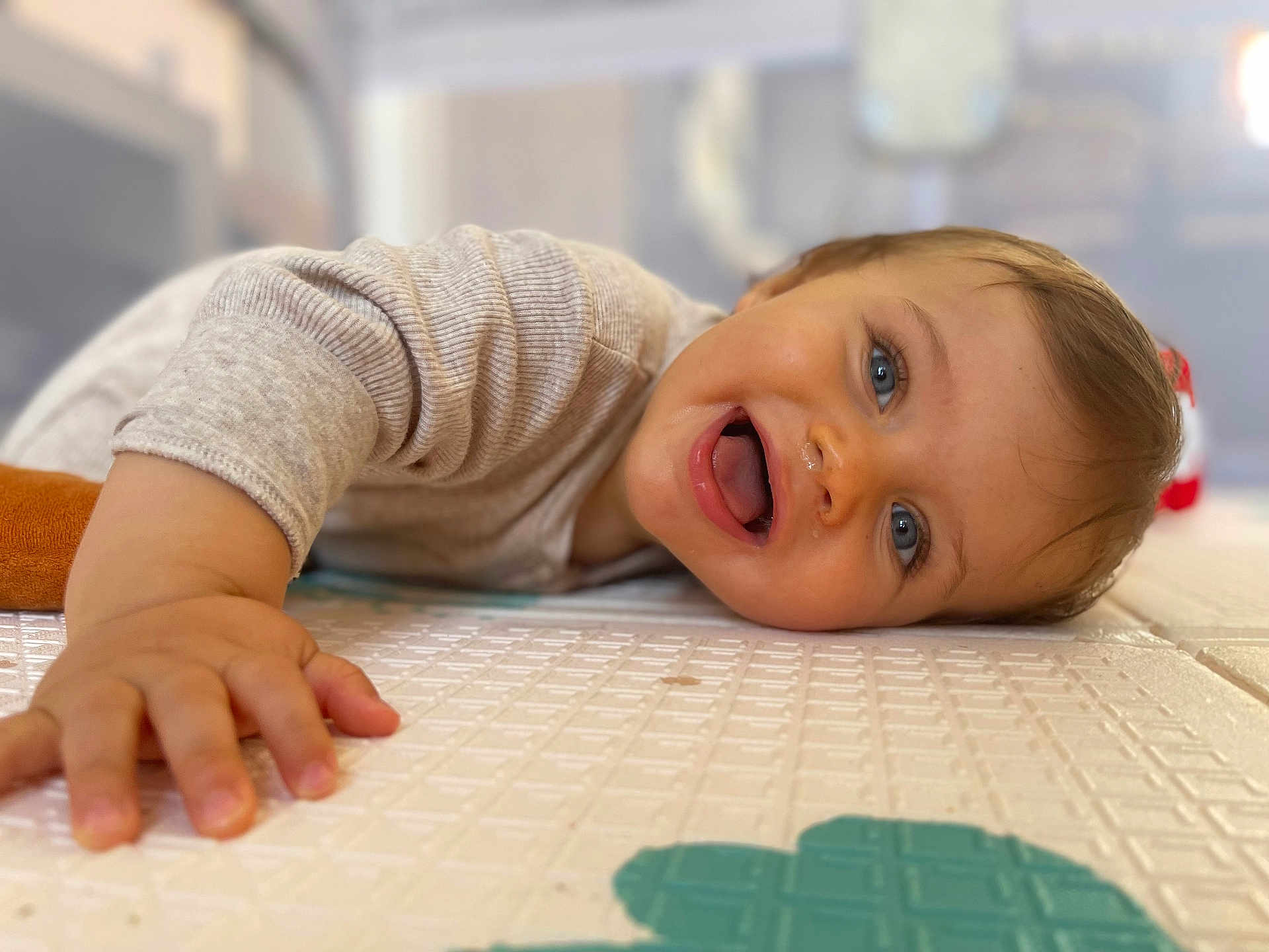 Sacha a rejoint le concours — aidez-le/la à gagner de superbes lots ! baby, child, smiling, happy, blue_eyes, face, hand, play_mat, indoor, close_up, person, infant, crawling, cute, skin, clothing, tongue, expression, young_child, toddler
