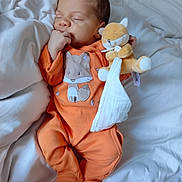 Léandro a rejoint le concours — aidez-le/la à gagner de superbes lots ! baby, infant, sleeping, orange_onesie, fox_design, plush_toy, stuffed_animal, bed, blanket, white_bedding, hand, face, cute, peaceful, indoors, soft_toy, child, person, lying_down, cozy