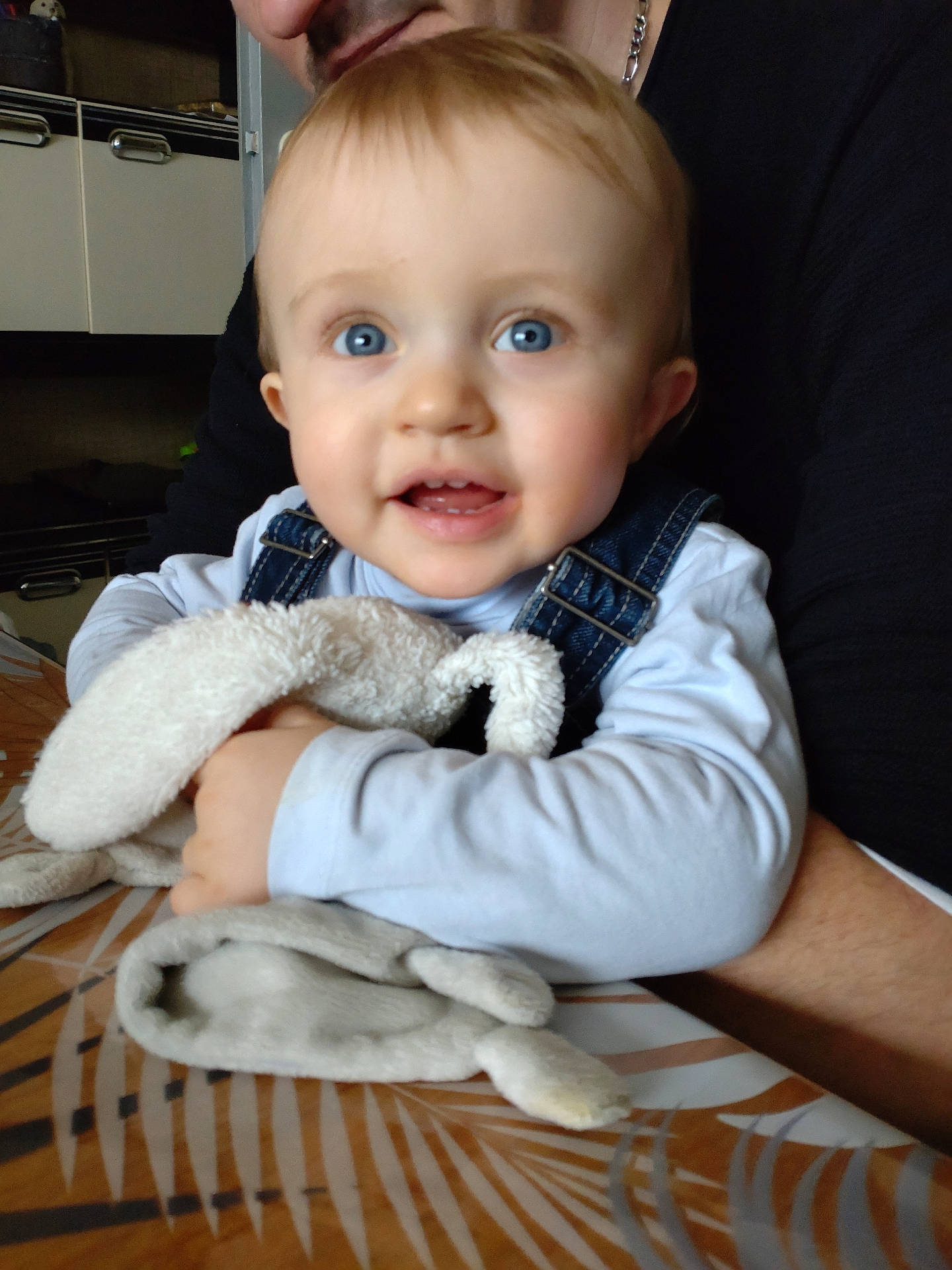 Hugo participe au concours pour gagner de l'argent avec cette photo : accessories, baby, bodypart, clothing, couch, face, finger, furniture, hand, happy, head, jeans, jewelry, necklace, pants, person, photography, portrait, sitting, smile