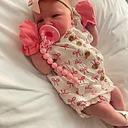 Kora joined the competition — help win amazing prizes! baby, infant, pacifier, mittens, headband, bow, white_bed, pink, clothing, newborn, cute, sleeping, person, lying_down, beaded_clip, soft, portrait, indoors, child, resting