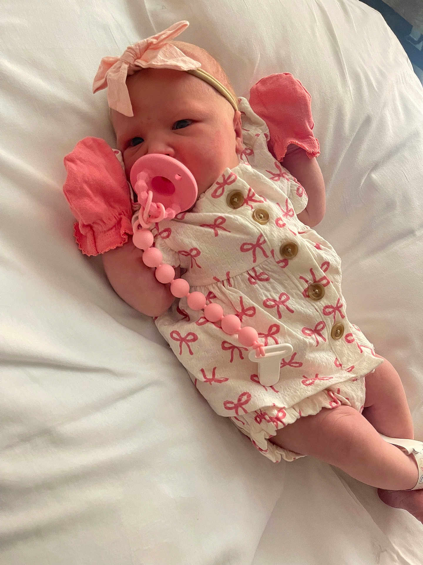 Kora joined the competition — help win amazing prizes! baby, infant, pacifier, mittens, headband, bow, white_bed, pink, clothing, newborn, cute, sleeping, person, lying_down, beaded_clip, soft, portrait, indoors, child, resting