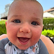 Sullivan joined the competition — help win amazing prizes! baby, smiling, face, closeup, outdoor, child, happy, cute, blue_eyes, skin, clothing, infant, nature, sunlight, palm_tree, background_blur, portrait, young_child, casual, joyful