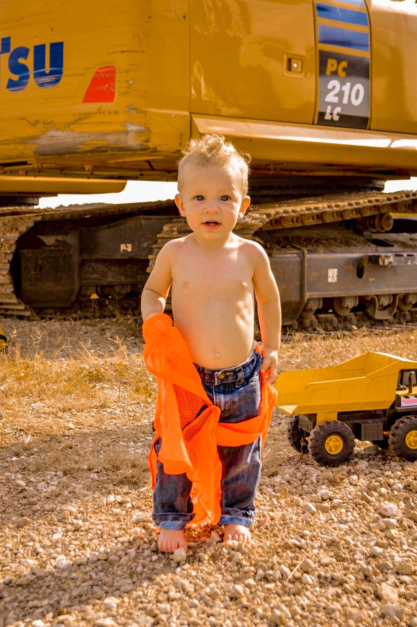 Lakota is registered to the contest to win money with this photo: asphalt, automotive_exterior, child, fun, happy, machine, mode_of_transport, motor_vehicle, person, railway, rolling, sitting, soil, tire, toddler, track, train, travel, vehicle, wheel