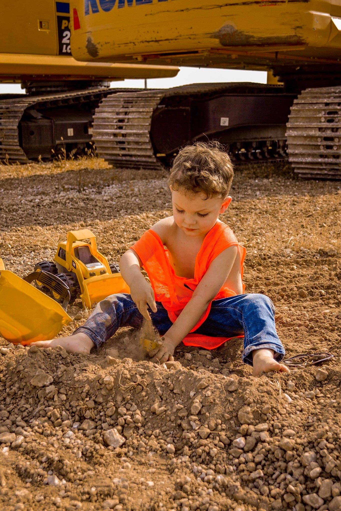 Braxton is registered to the contest to win money with this photo: automotive_tire, blue_collar_worker, construction, construction_equipment, construction_worker, engineering, field, fun, gas, machine, people_in_nature, person, recreation, rolling, sand, soil, t_shirt, tire, toddler, vehicle