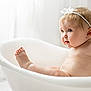 baby, bathtub, child, headband, blue_eyes, skin, cute, infant, naked, white, minimalistic, soft_light, portrait, sitting, chubby, curious, indoors, clean, tub, water_drops