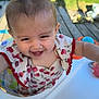 baby, child, smiling, pigtails, high_chair, outdoor, sunlight, grass, wooden_deck, dress, cherry_pattern, happy, person, infant, playful, cute, face, portrait, colorful, summer