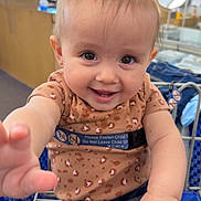 Allyanna joined the competition — help win amazing prizes! baby, child, shopping_cart, pigtails, smiling, cute, indoor, clothing, jeans, leopard_print, person, hand, face, happy, retail, store, seatbelt, metal, holding, portrait