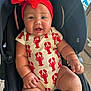 baby, bow, bracelet, car_seat, child, chubby, cute, floor_tile, happy, indoor, infant, lobster_pattern, onesie, person, plump_arms, plump_legs, portrait, red_headband, seat_belt, smiling