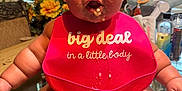 Mollie joined the competition — help win amazing prizes! arms, baby, bib, child, chubby, curious, cute, dining_room, expression, face, feet, flowers, food, glass_table, indoor, legs, messy, mouth, table, window_blinds