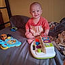 Wayln joined the competition — help win amazing prizes! baby, child, toy, bed, smile, red_shirt, indoor, blanket, play, young, infant, cute, happy, person, furniture, room, colorful, plastic, sitting, face
