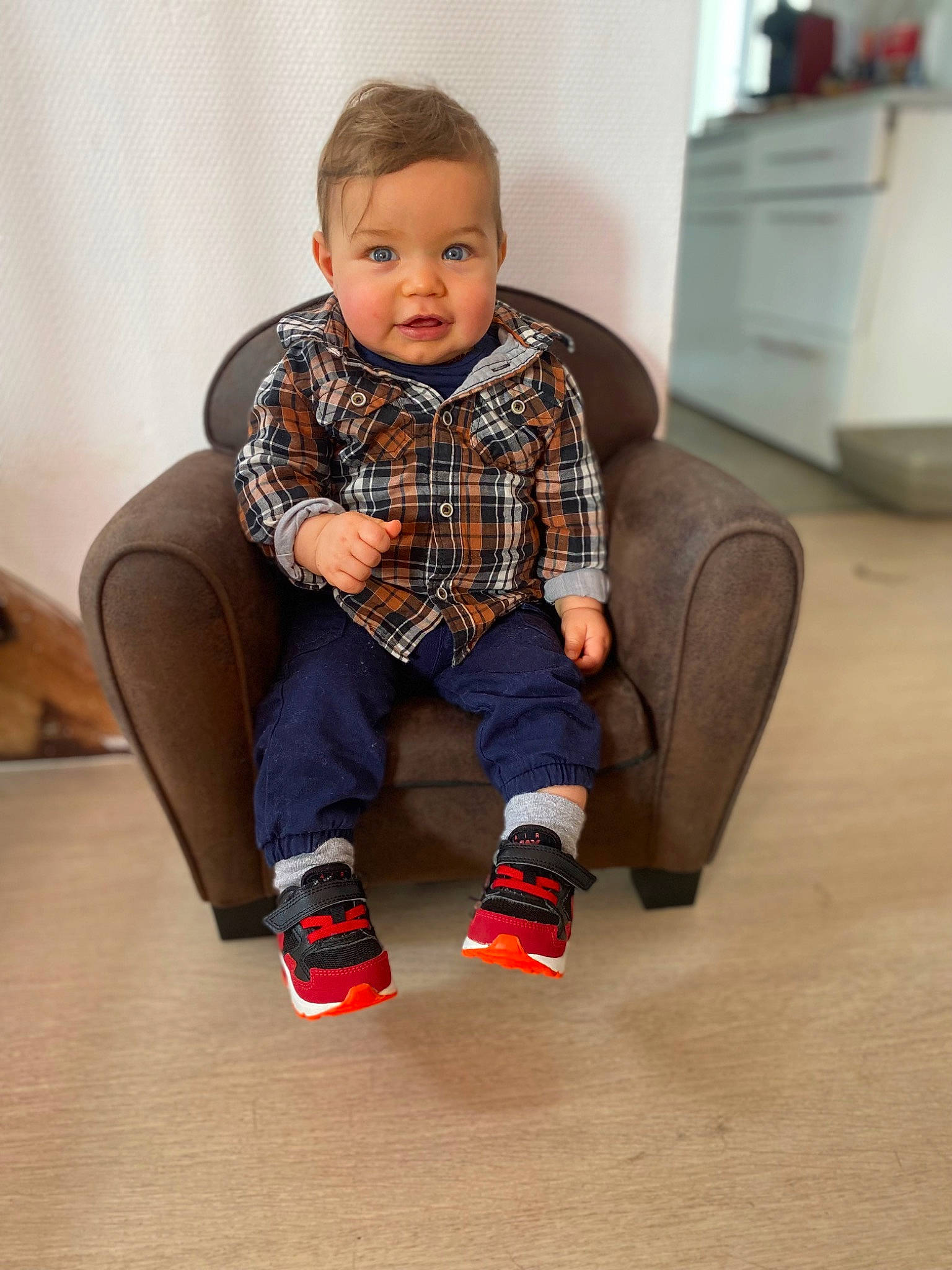 Jayden a rejoint le concours — aidez-le/la à gagner de superbes lots ! baby, baby_toddler_clothing, collar, comfort, couch, dress_shirt, eye, face, floor, flooring, head, knee, pattern, person, plaid, sitting, sleeve, smile, tartan, toddler