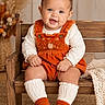 baby, child, infant, portrait, sitting, smiling, happy, orange_outfit, overalls, wooden_chair, booties, white_socks, blanket, autumn_decor, flowers, indoor, cozy, carpet, fashion, photography