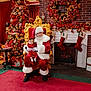 santa_claus, baby, christmas_tree, christmas_decorations, wreath, stockings, gifts, holiday, festive, red_carpet, golden_chair, fireplace, brick_wall, indoor, celebration, person, child, smiling, holiday_spirit, winter