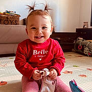 Maria a rejoint le concours — aidez-le/la à gagner de superbes lots ! child, baby, toddler, smiling, pigtails, red_sweater, striped_leggings, play_mat, toy, indoor, sitting, happy, portrait, cheeks, teeth, hands, socks, living_room, toy_basket, floor_padding