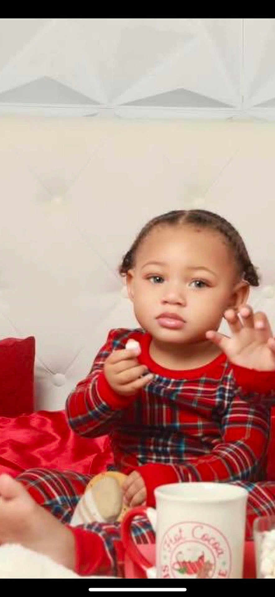 Samir joined the competition — help win amazing prizes! toddler, child, pajamas, red_clothing, plaid, bed, pillow, headboard, marshmallow, hand, face, expression, holiday, mug, cup, cozy, indoor, cute, table, sitting