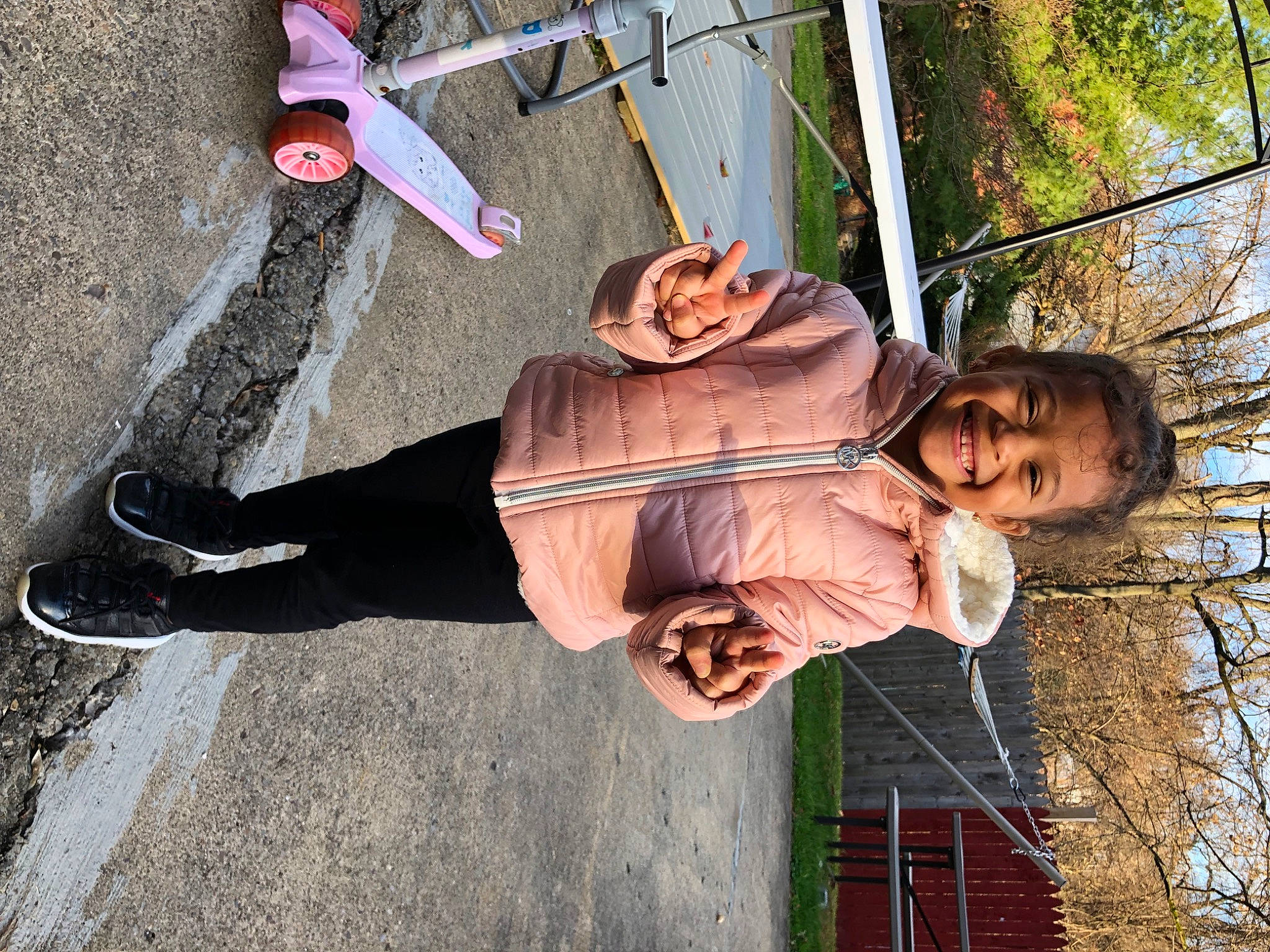 Milani is registered to the contest to win money with this photo: asphalt, boot, child, cool, fun, grass, happy, hat, human_leg, joy, leg, leisure, person, road_surface, shadow, shoe, sitting, smile, sneakers, street