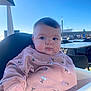 baby, candid, chair, cheeks, cherry_pattern, eyes, feeding_time, hand, highchair, infant, outdoor, patio, person, portrait, restaurant_terrace, sky, sunlight, sweatshirt, table, toy