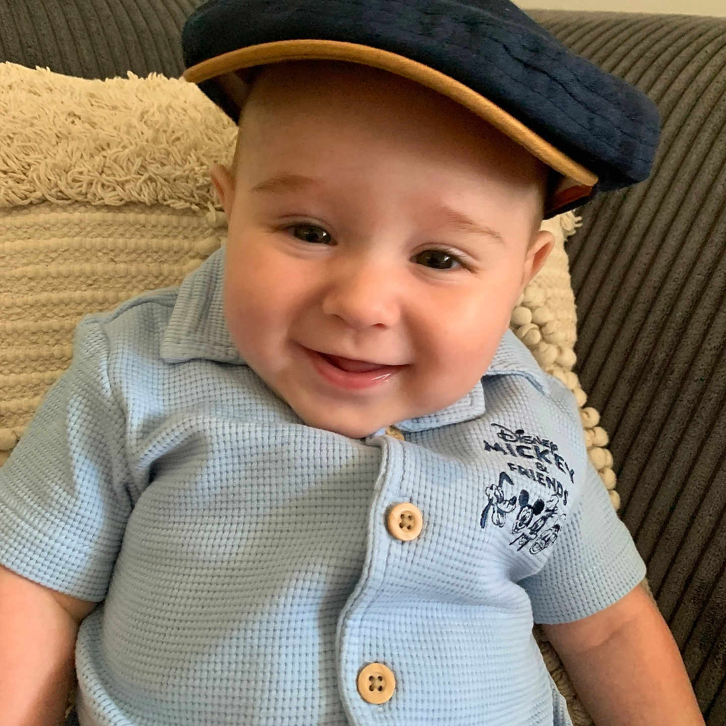 Paolo a rejoint le concours — aidez-le/la à gagner de superbes lots ! baby, blue_shirt, buttoned_shirt, cap, child, clothing, couch, cute, face, happy, hat, indoor, infant, mickey_and_friends, person, pillow, portrait, sitting, smiling, textured_pillow