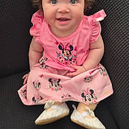 Vanity is registered to the contest to win money with this photo: baby, child, curly_hair, dress, pink, minnie_mouse, shoes, smile, sitting, chair, indoor, cute, happy, person, portrait, infant, young_child, clothing, fashion, eyes