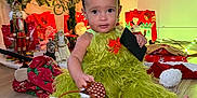 Noah is registered to the contest to win money with this photo: toddler, child, christmas_tree, holiday_decorations, gift_bags, grinch_costume, headband, wooden_floor, festive, indoors, lights, ornaments, reindeer_headband, christmas, cute, sitting, present, toy, celebration, holiday