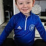 Nolan participe au concours pour gagner de l'argent avec cette photo : adidas, blue_jacket, boy, casual, child, cute, face, furniture, happy, home, indoor, living_room, person, portrait, short_hair, sitting, smiling, sportswear, television, young
