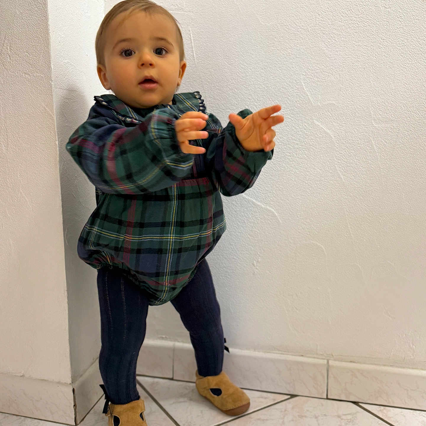 Julen a rejoint le concours — aidez-le/la à gagner de superbes lots ! baby, brown_shoes, casual_clothing, child, corner, curious, cute, exploring, home, indoor, navy_leggings, person, plaid_jacket, portrait, small_child, standing, tile_floor, toddler, white_wall, young_child