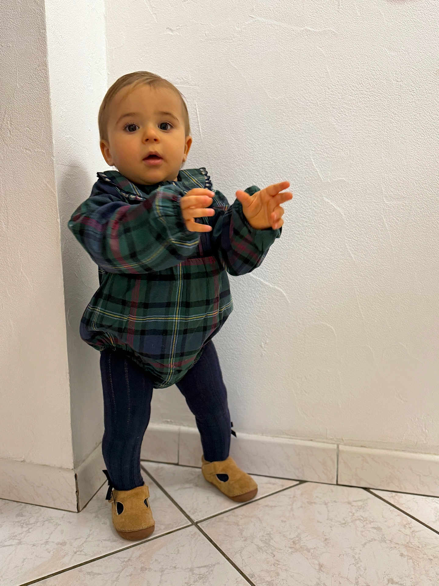 Julen a rejoint le concours — aidez-le/la à gagner de superbes lots ! toddler, child, standing, plaid_jacket, navy_leggings, brown_shoes, indoor, tile_floor, white_wall, curious, young_child, person, small_child, portrait, casual_clothing, cute, baby, exploring, corner, home