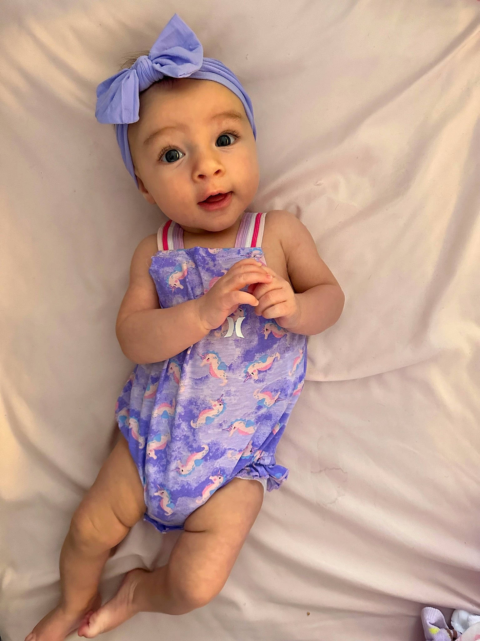 Charlotte is registered to the contest to win money with this photo: baby, baby_toddler_clothing, child, day_dress, dress, electric_blue, eye, finger, happy, hat, human_leg, one_piece_garment, pattern, person, pink, purple, skin, sleeve, surprise, textile