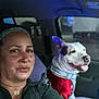 accessory, animal, car, casual_clothing, collar, dog, friendship, headband, human, indoor, pet, portrait, red_vest, resting, seat, selfie, smile, tongue_out, window, woman