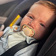 Eric joined the competition — help win amazing prizes! baby, pacifier, car_seat, child, infant, face, close_up, seatbelt, clothing, light, natural_light, portrait, cute, young_child, sitting, secure, safety, soft_focus, indoor, expression