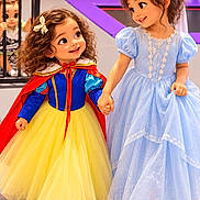 Aisha is registered to the contest to win money with this photo: children, girls, princess, costumes, snow_white, blue_dress, yellow_skirt, red_cape, fairy_tale, holding_hands, smiling, curly_hair, hair_bows, indoor, playground, railing, brick_wall, colorful, portrait, dress_up