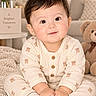 baby, child, infant, portrait, smiling, sitting, indoor, nursery, teddy_bear, stuffed_animal, blanket, carpet, sweater, onesie, cream_clothing, flowers, bouquet, furniture, cozy, close_up