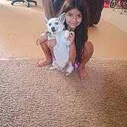 Bullet is registered to the contest to win money with this photo: barefoot, carpet, casual, child, crouching, cute, dog, domestic_animal, furniture, happy, home, indoor, living_room, long_hair, person, pet, playful, smiling, white_dog, young_girl