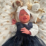 Alwena participe au concours pour gagner de l'argent avec cette photo : baby, infant, plush_toy, blanket, star_pattern, headband, dress, white_sleeves, lying_down, cute, soft_toys, expression, tongue_out, cozy, indoors, child, newborn, fabric, comfort, adorable