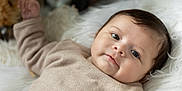 Kélyo participe au concours pour gagner de l'argent avec cette photo : baby, infant, face, portrait, lying_down, cozy, cute, soft_texture, fluffy, white_background, clothing, child, smile, hair, skin, indoors, peaceful, closeup, warm, young