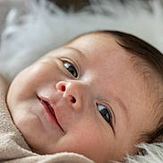 Kélyo participe au concours pour gagner de l'argent avec cette photo : baby, infant, face, smile, close_up, soft, blanket, fluffy, cute, young_child, skin, eyes, head, portrait, lying_down, warm, comfort, expression, natural_light, cozy