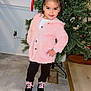 child, girl, pink_jacket, black_pants, black_shoes, pink_shoelaces, bow, christmas_tree, holiday, indoor, pose, smile, floor, wall, decorations, festive, cute, fashion, young, happy