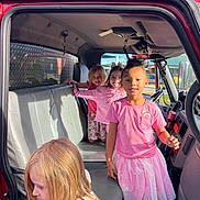 Suelena is registered to the contest to win money with this photo: child, children, vehicle, red, truck, interior, seat, pink_clothing, girl, smile, sunlight, window, dashboard, happy, playful, curly_hair, blonde_hair, casual_clothing, indoor, daylight