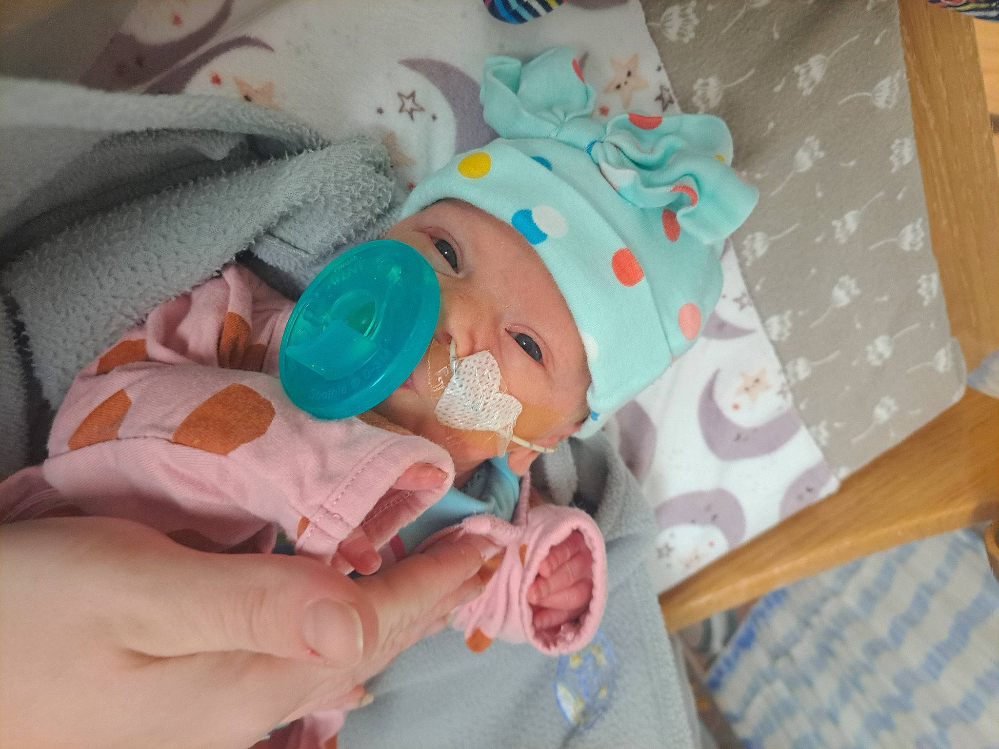 Octavia is registered to the contest to win money with this photo: baby, baby_products, baby_toddler_clothing, child, comfort, event, finger, hand, hat, health_care, linens, nail, person, pink, room, skin, smile, textile, thumb, toddler