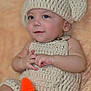 baby, infant, crochet, hat, carrot, soft_texture, cute, smile, child, knitwear, handmade, cozy, portrait, indoor, fuzzy_background, skin, cute_expression, small_hands, relaxed, seated
