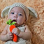 Orion is registered to the contest to win money with this photo: baby, crochet, knitted, bunny_ears, carrot, plush, soft, cute, child, infant, portrait, hands, blue_eyes, expression, background, fuzzy, texture, closeup, costume, adorable