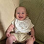 baby, smiling, infant, bib, clothing, couch, blanket, happy, sitting, indoor, child, person, cute, skin, face, head, hand, foot, expression, comfort