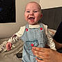 Elijah is registered to the contest to win money with this photo: baby, child, smiling, laughing, denim_overalls, spiderman, hand, bed, bedroom, poster, person, clothing, infant, happy, indoor, cute, support, skin, face, apparel