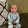 Elijah joined the competition — help win amazing prizes! baby, infant, couch, pillow, rattle, blue_clothing, sitting, indoors, child, cute, wide_eyes, expression, soft_lighting, knitted_blanket, home, portrait, furniture, cozy, hands, footed_pajamas